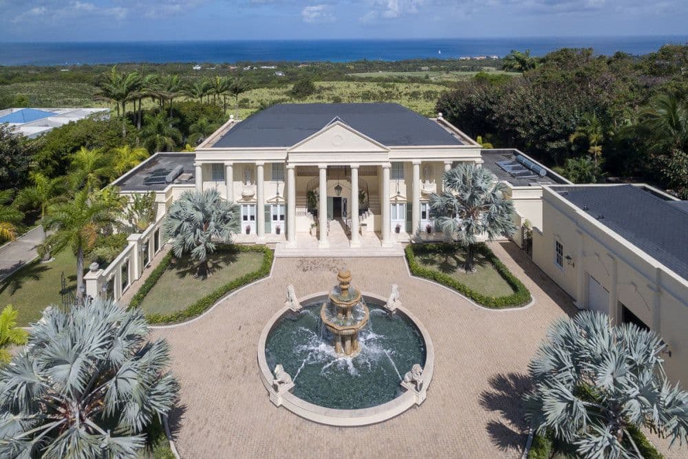 Aerial view of The Ridge's columned portico, courtyard fountain and gardens above the Caribbean Sea