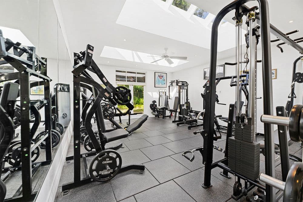 Multi-level home gym with weight machines and cable stations under skylights at The Ridge