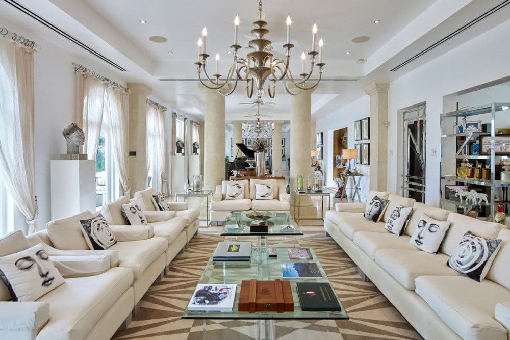 Formal living room with chandeliers, cream sofas and a grand piano at The Ridge