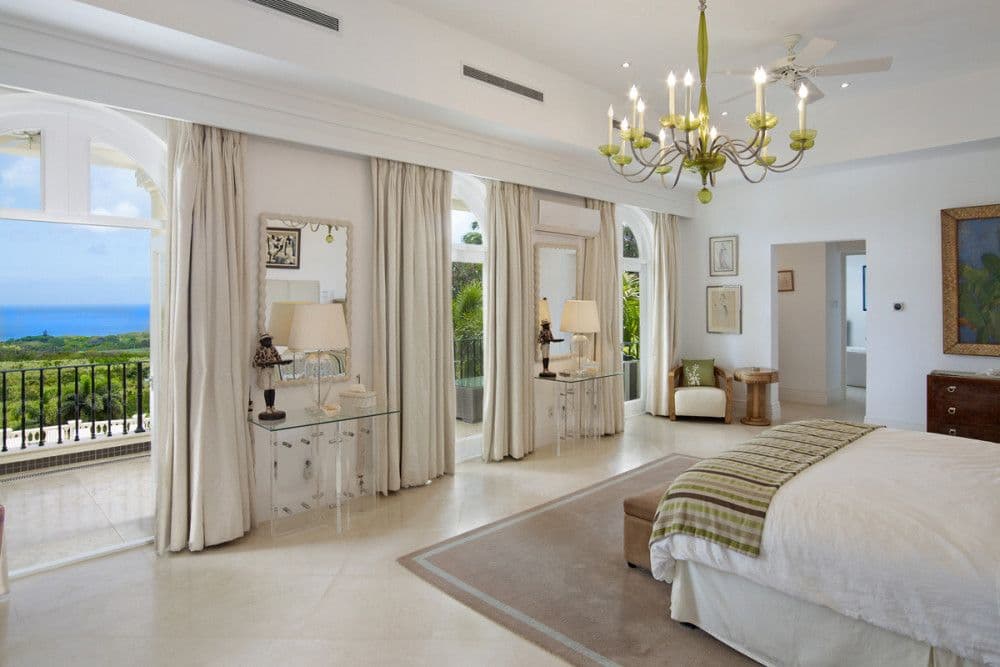 Master bedroom opening through arched doors to a sea-view balcony at The Ridge