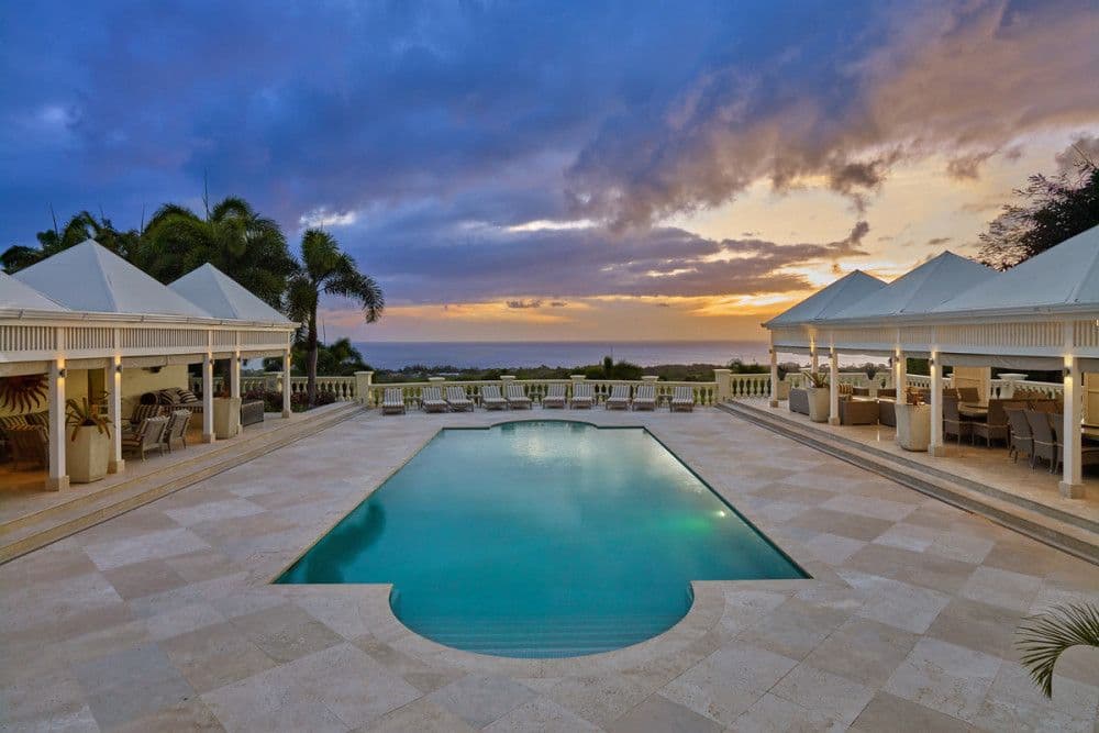 Pool and cabana pavilions at sunset with elevated Caribbean Sea views at The Ridge