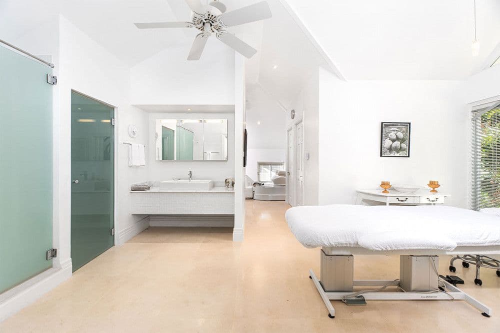 Spa treatment room with a massage table and vaulted ceiling at The Ridge