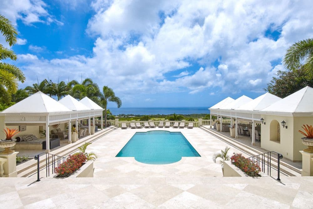 Poolside terrace with loungers and elevated sea views at The Ridge