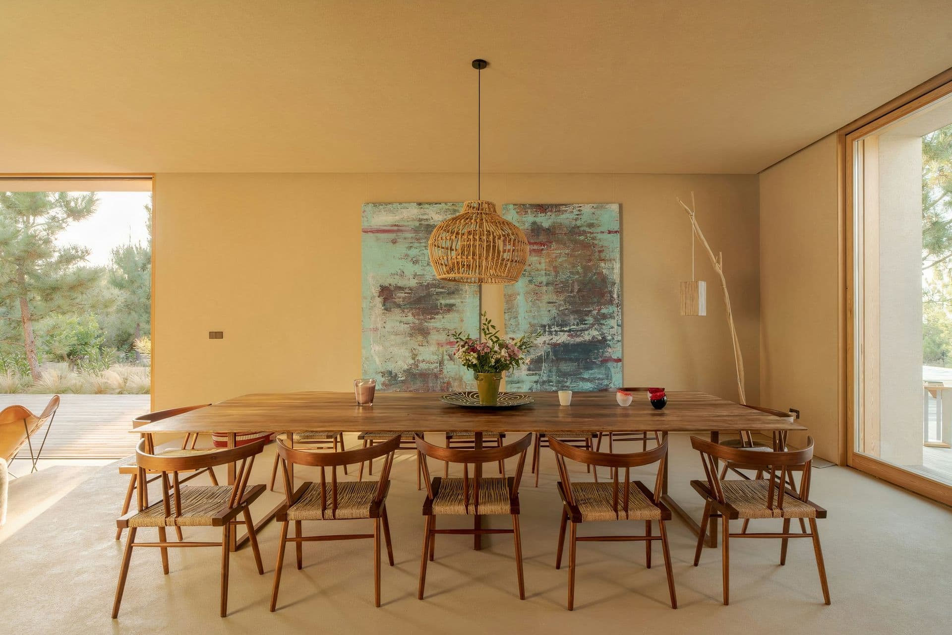 Indoor dining table for twelve beneath a woven pendant at Mighty Pine