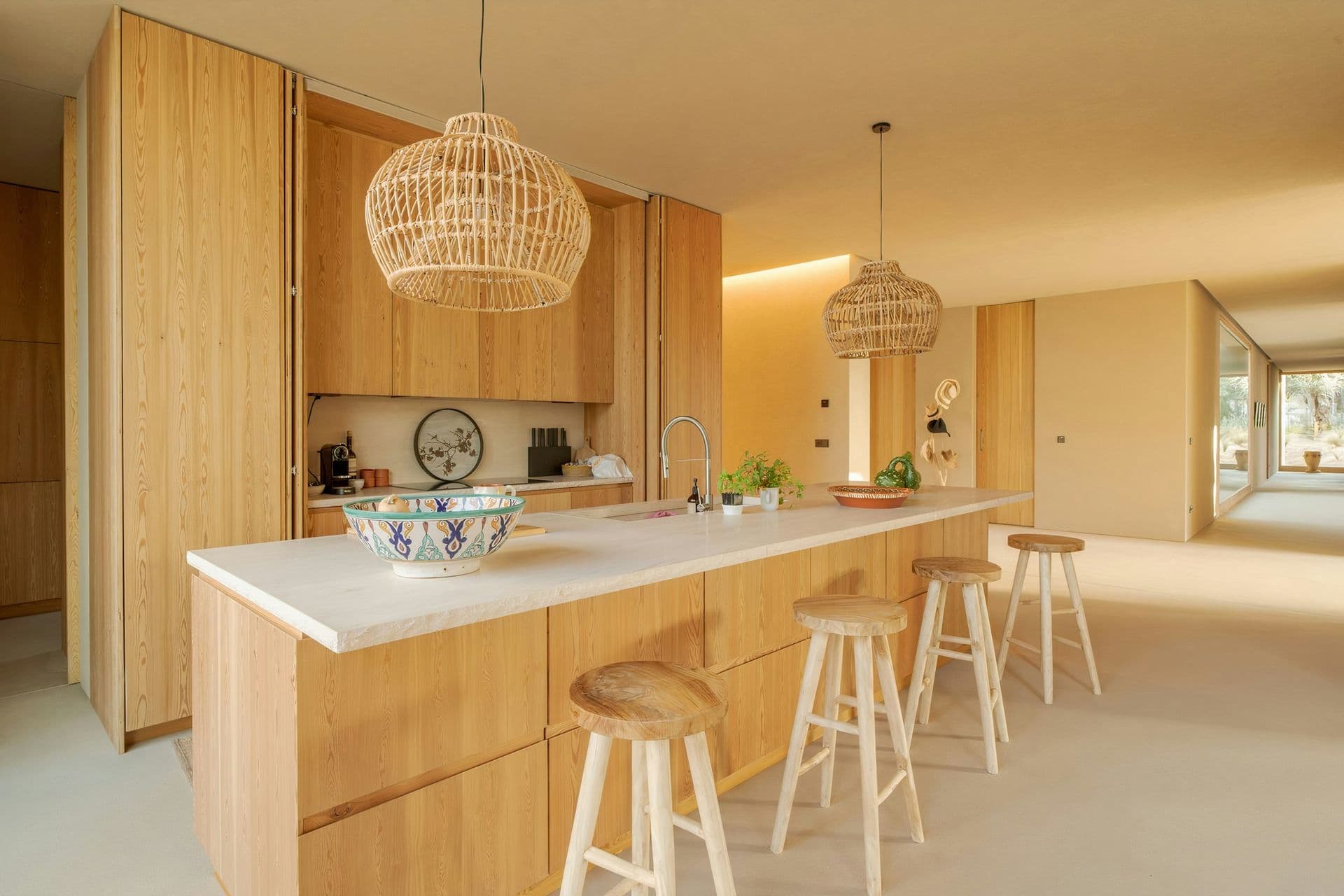 Oak kitchen with an island, breakfast stools and rattan pendants at Mighty Pine
