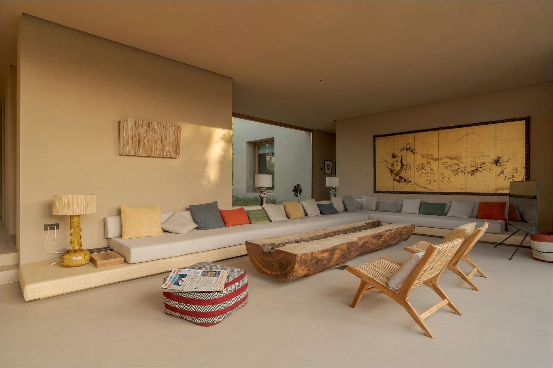 Sunken living room with a live-edge timber table and long sofa at Mighty Pine