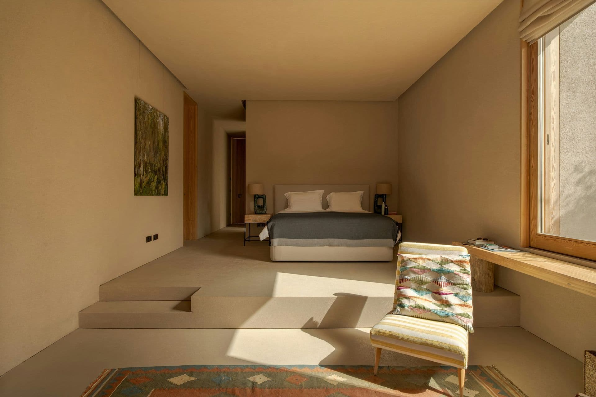 Bedroom set on a raised plinth with steps and a garden view at Mighty Pine