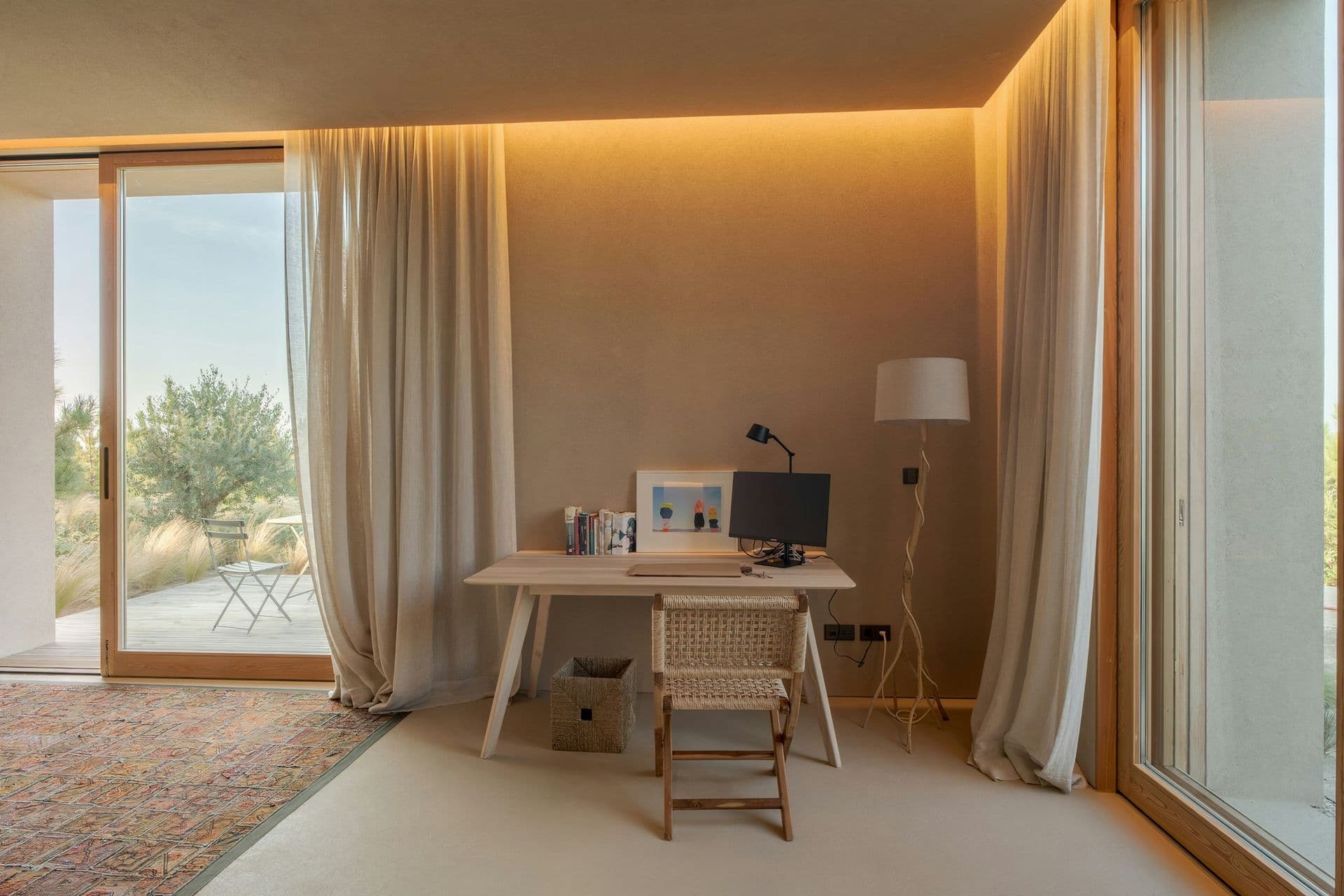 Study desk beside full-height curtains and garden doors at Mighty Pine