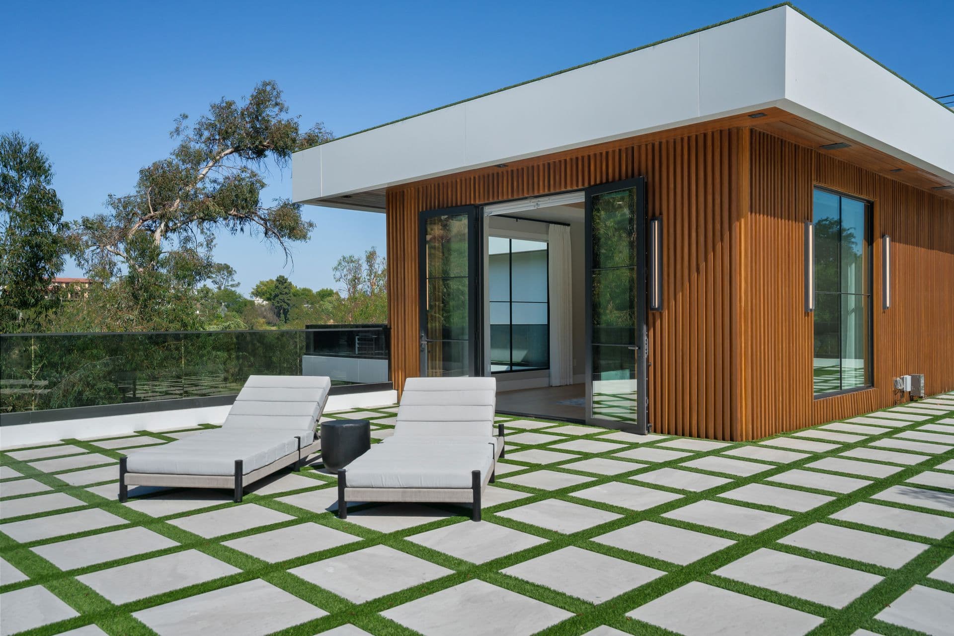 Timber-clad facade with loungers on a checkerboard lawn at Bel-Air Oasis, Los Angeles