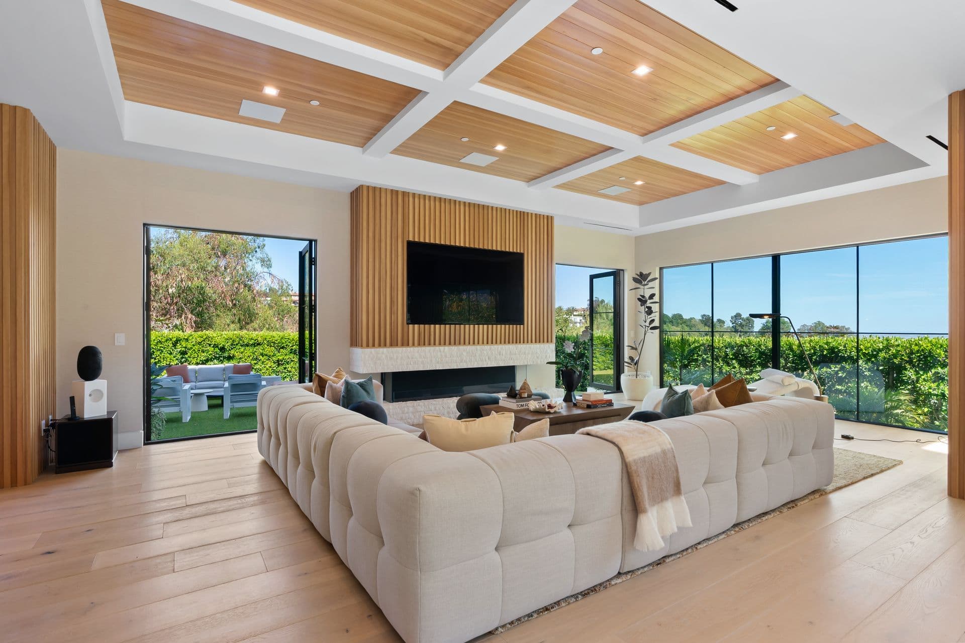 Living room with a fireplace and television opening to the garden at Bel-Air Oasis, Los Angeles