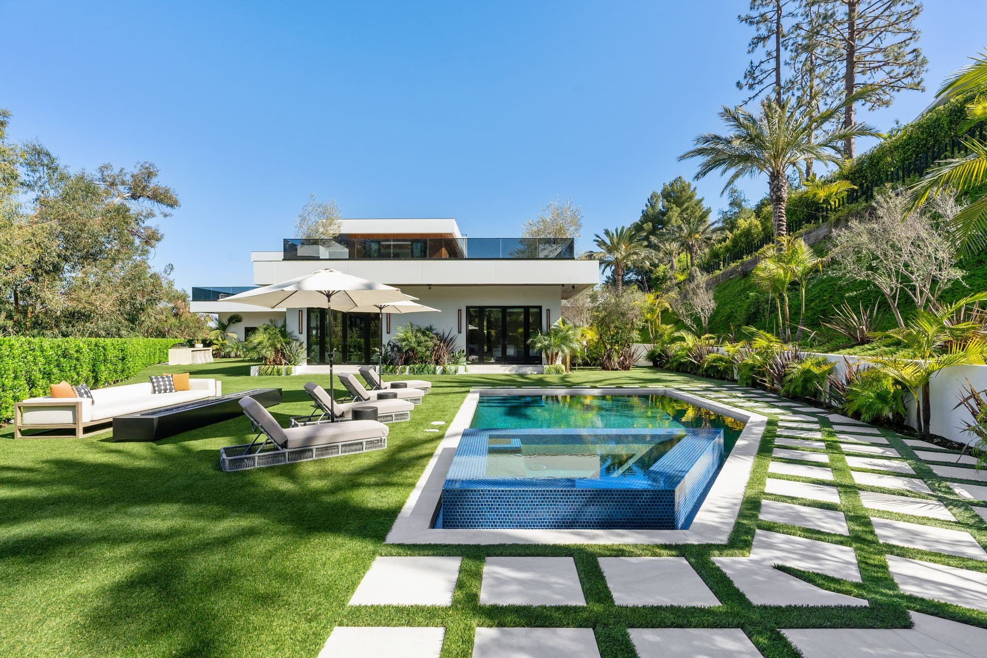 Pool and spa on a checkerboard lawn beside the modern mansion at Bel-Air Oasis, Los Angeles