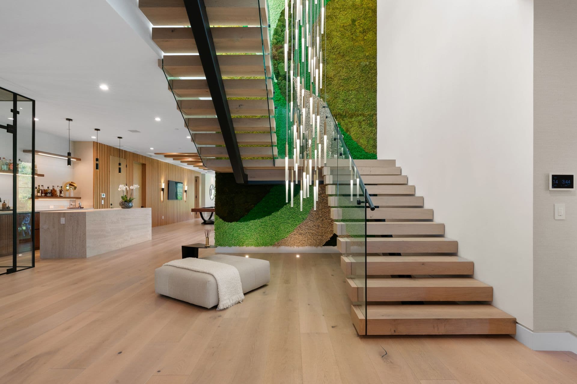 Floating timber staircase beside a living moss wall at Bel-Air Oasis, Los Angeles