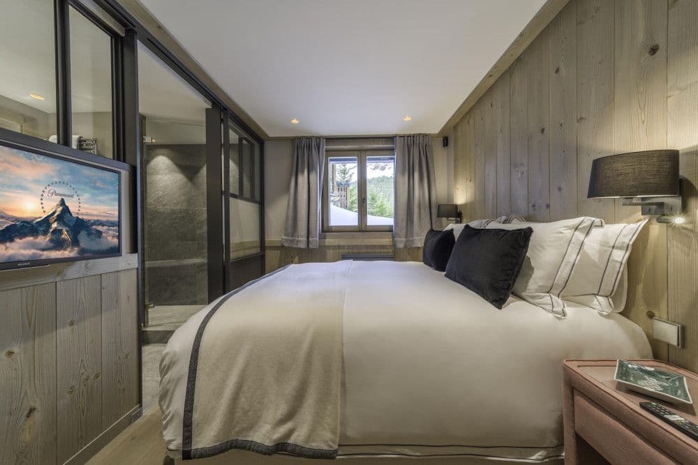 Double bedroom panelled in warm timber at Courchevel 13