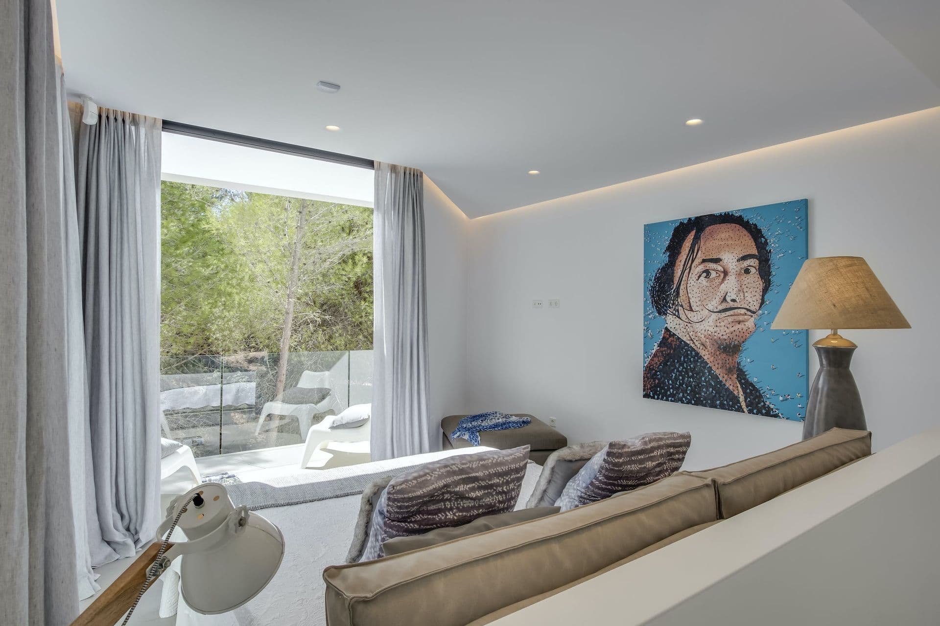 Double bedroom with a portrait artwork and a sitting area at Dancing Shadows, Ibiza