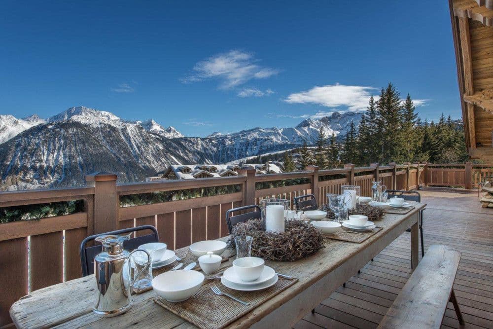 Terrace dining table with panoramic mountain views at Courchevel 17