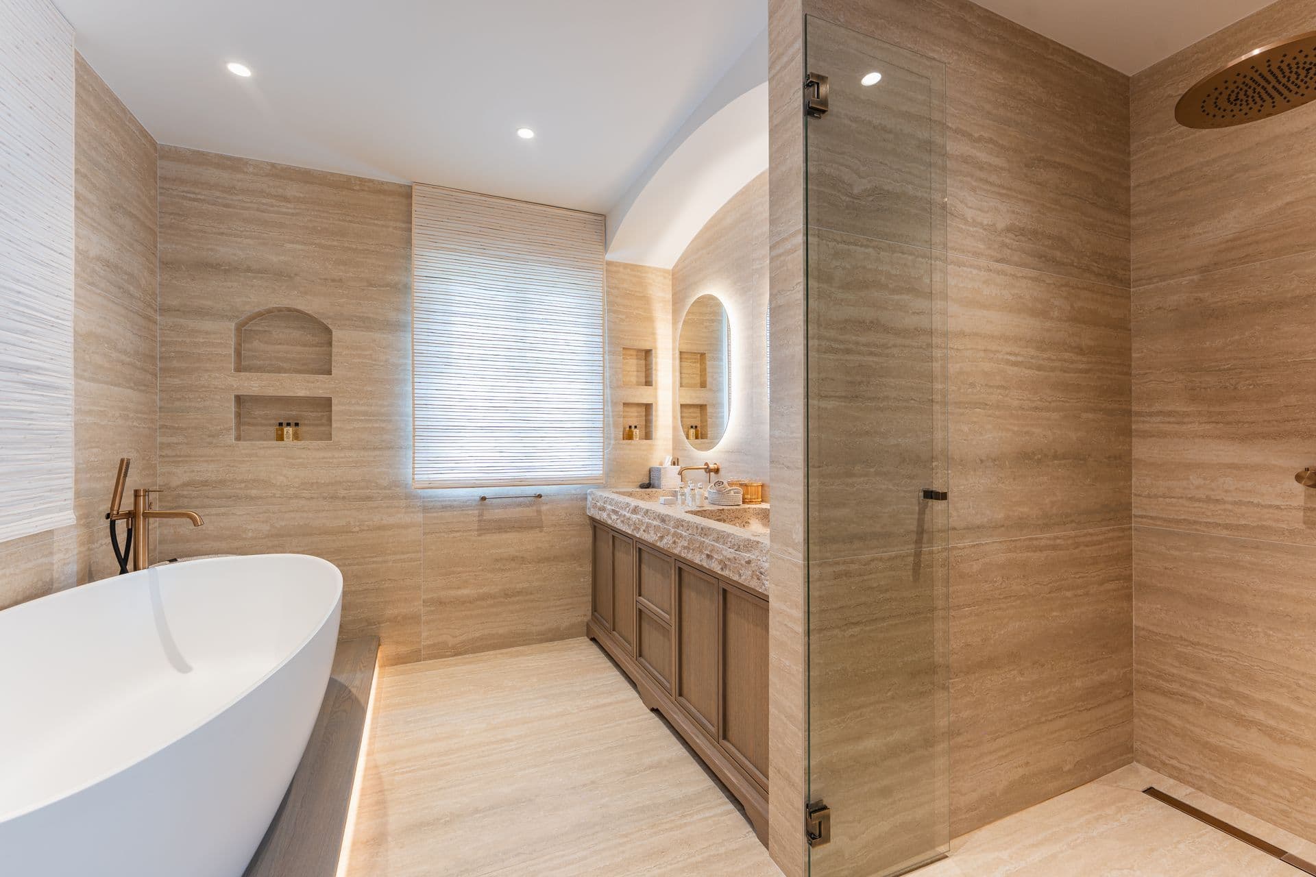 Bathroom with a freestanding oval tub beside a glass shower.