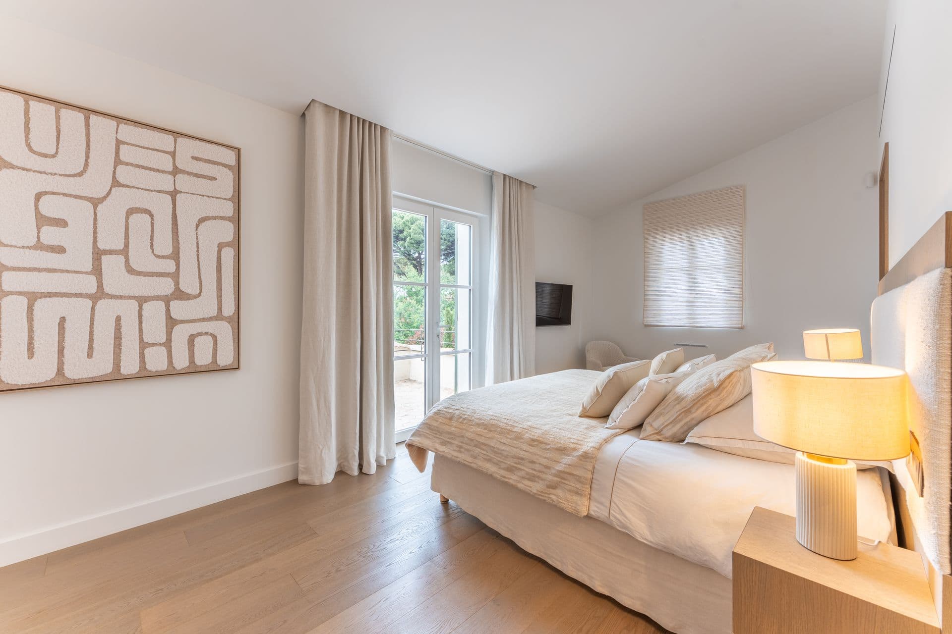 Bedroom with graphic artwork above the bed and a reading chair.