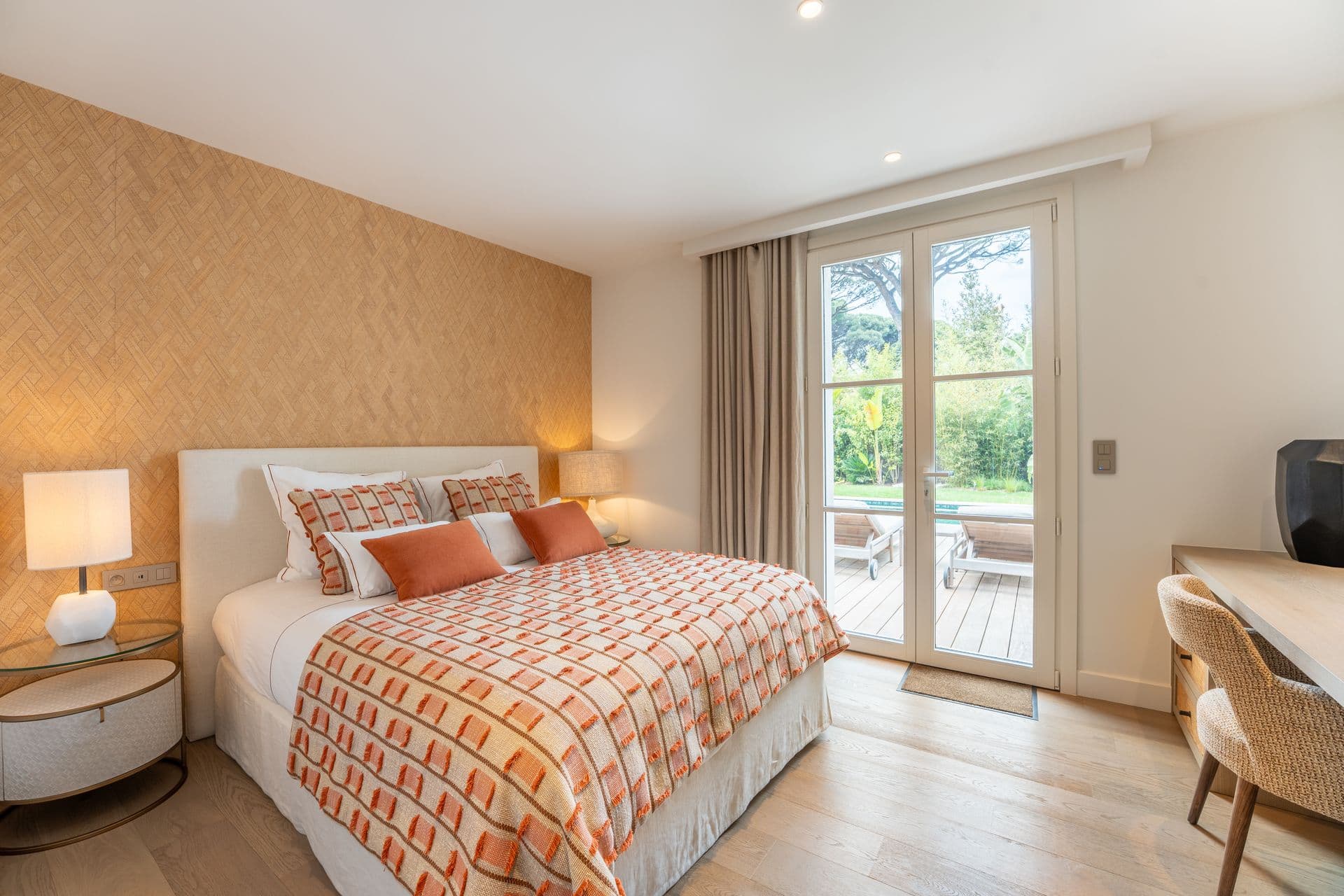 Bedroom with a bold orange patterned bedspread and terrace access.