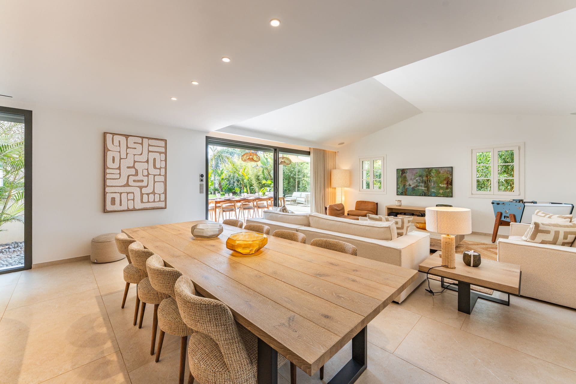 Dining table in the open plan living area with rattan pendant lighting.