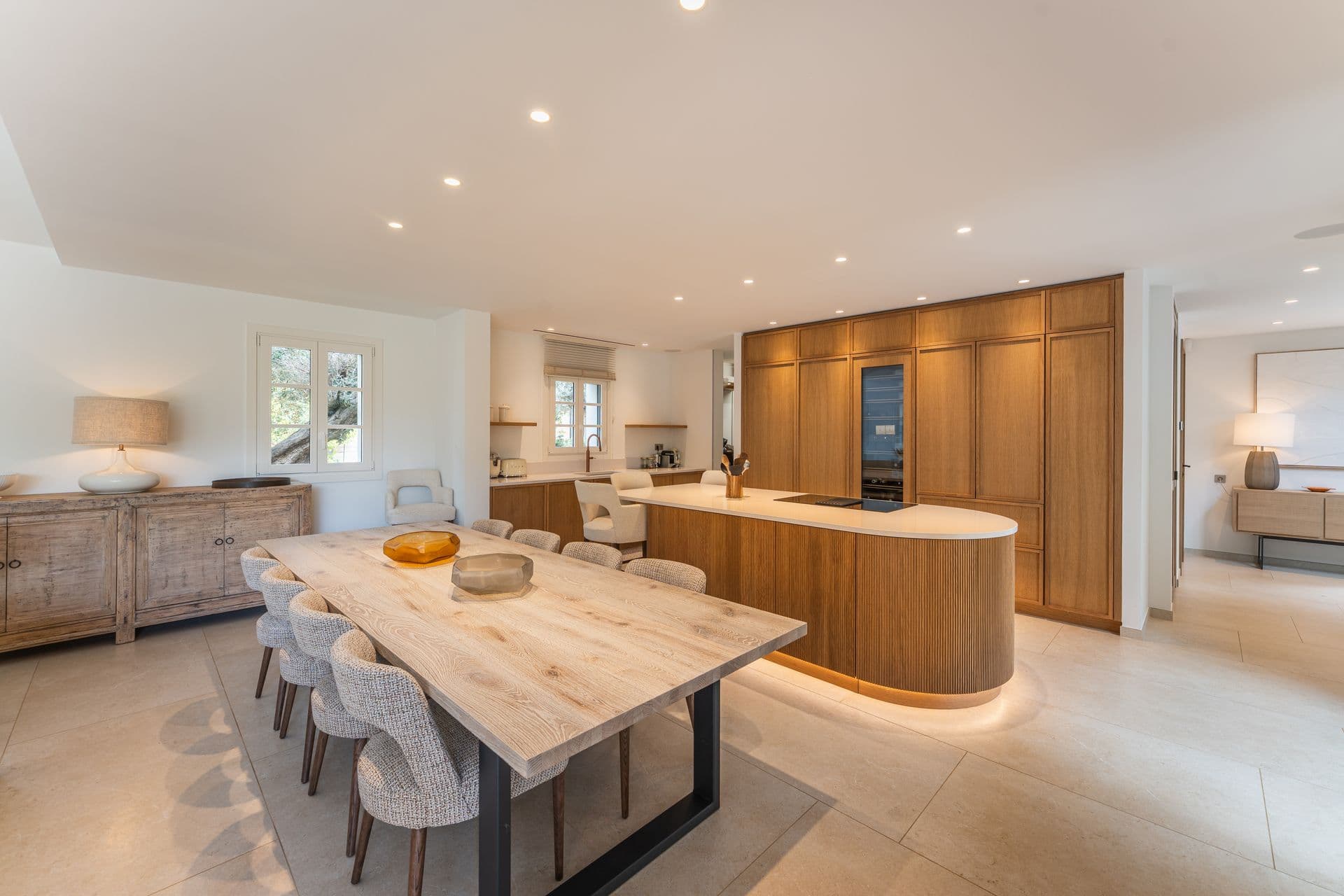 Kitchen with a curved wooden island and integrated appliances.