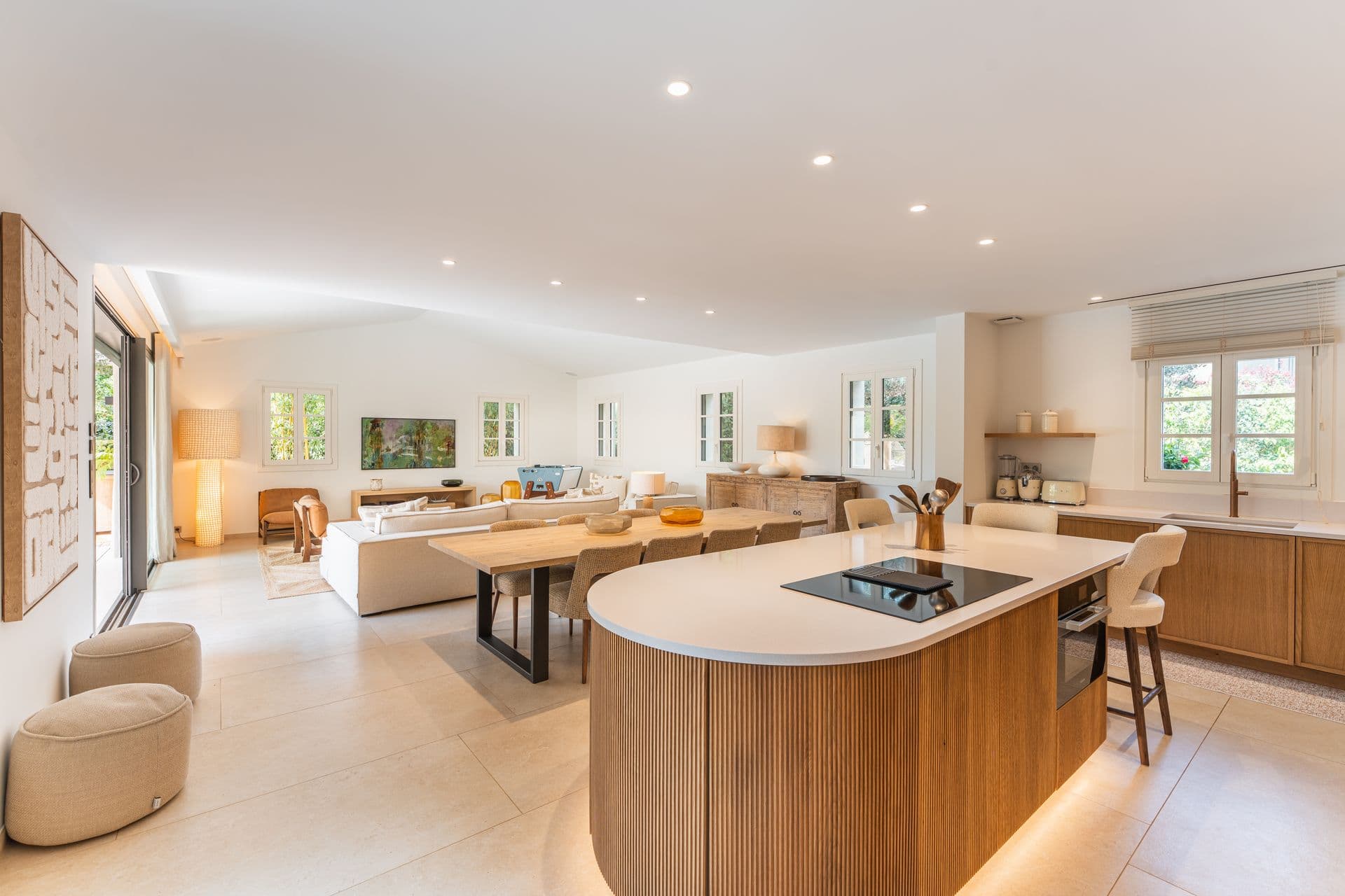 Open plan living room flowing into the kitchen, finished in warm oak tones.