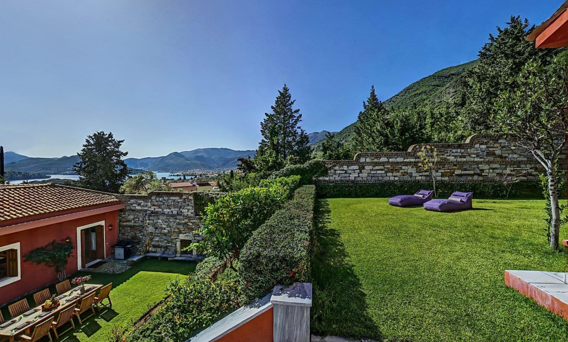 Manicured lawned garden with hedging and countryside views beyond the villa