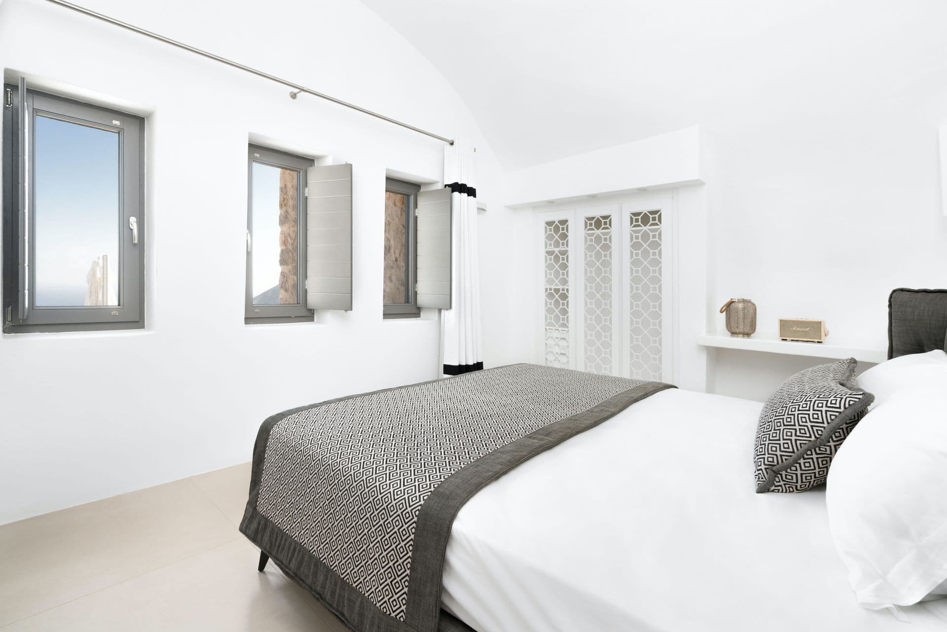 Bedroom with twin arched windows framing a sea view.