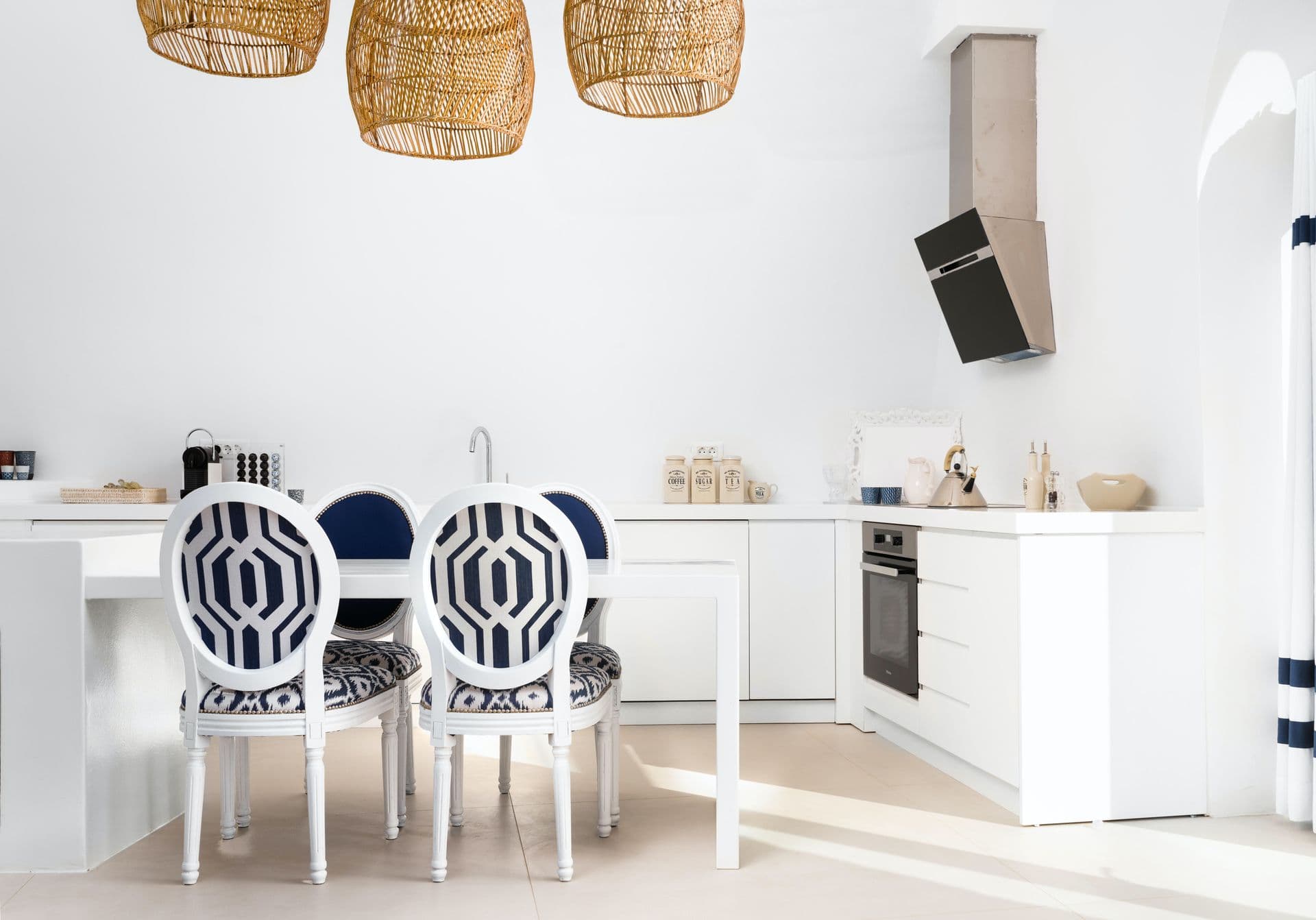 Dining area with geometric patterned chairs beside the open kitchen.