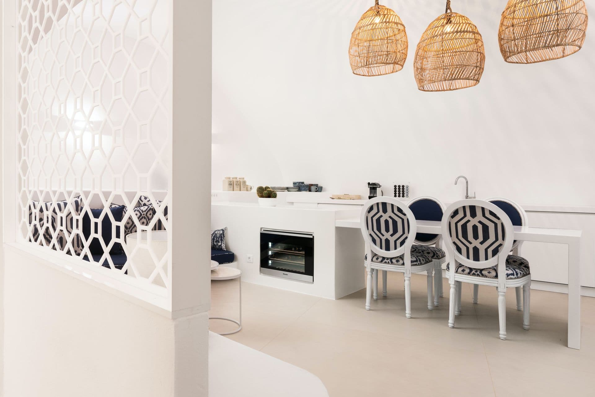 Kitchen and dining nook with woven pendant lights and patterned chairs.