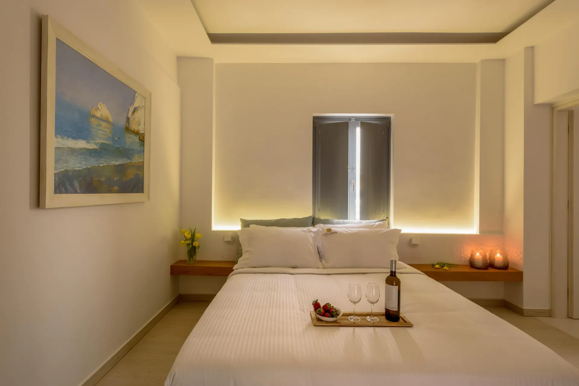 Bedroom at Gaia's Rest with a seaside painting and warm lighting.