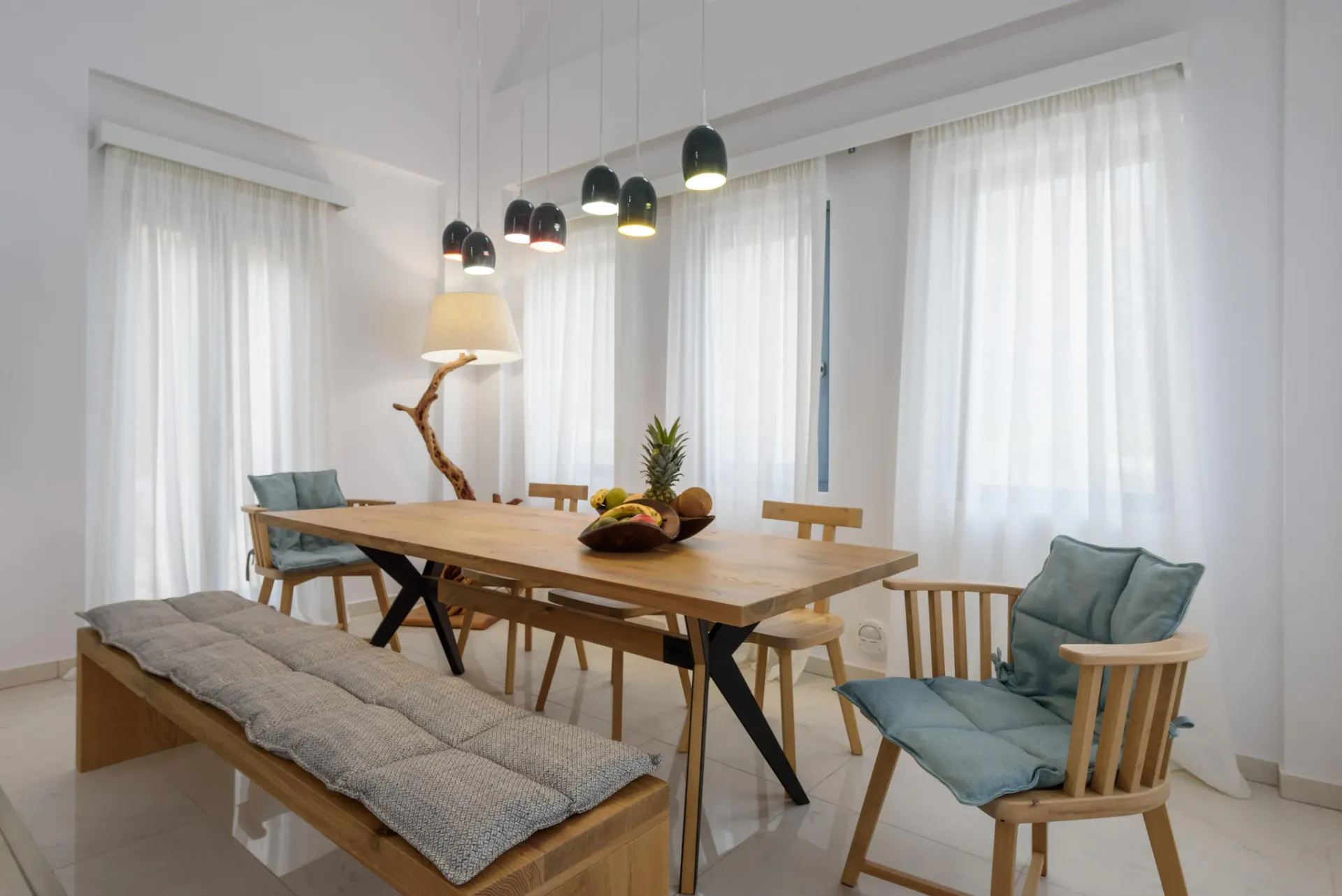 Wood dining table at Gaia's Rest, seating for eight beneath pendant lighting.