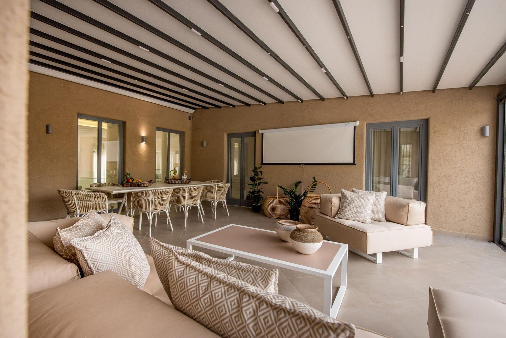 Shaded pergola lounge at Gaia's Rest with woven armchairs and driftwood accents.