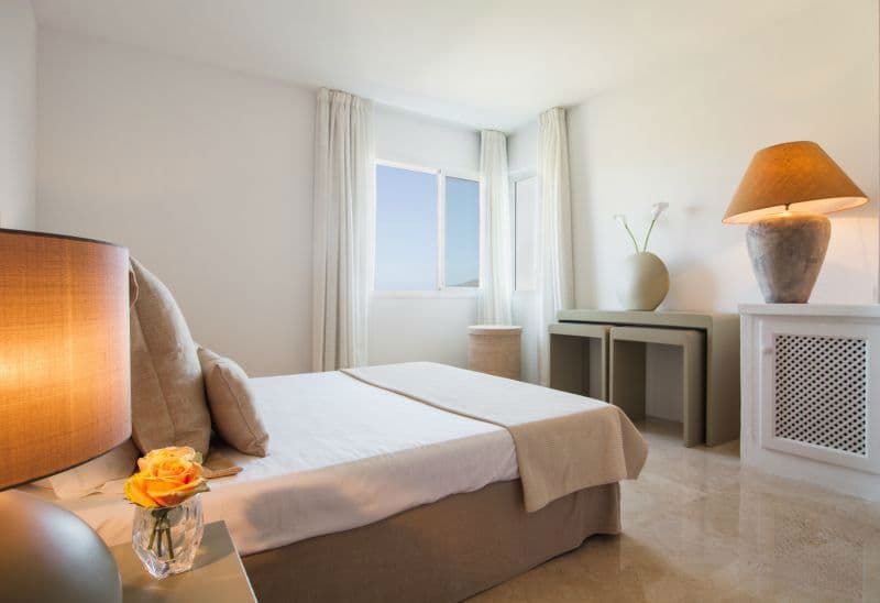 Guest bedroom with a upholstered headboard and fresh flowers on the nightstand at Moon Kite