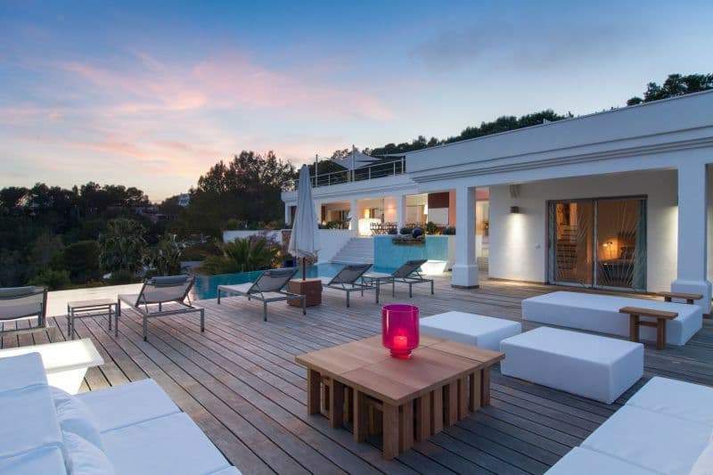 Modern white villa and pool lit at dusk with a soft pink sky at Moon Kite