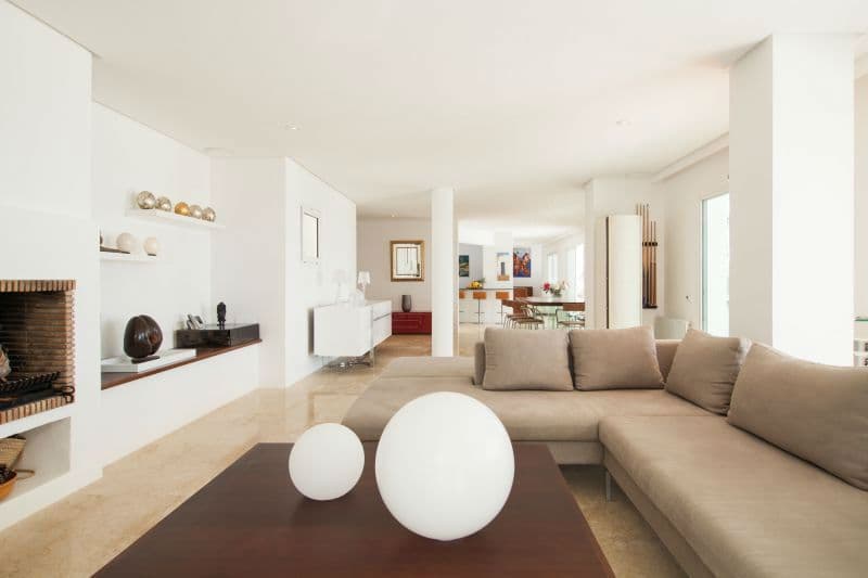 Open plan living room with a corner sofa and a stone fireplace at Moon Kite