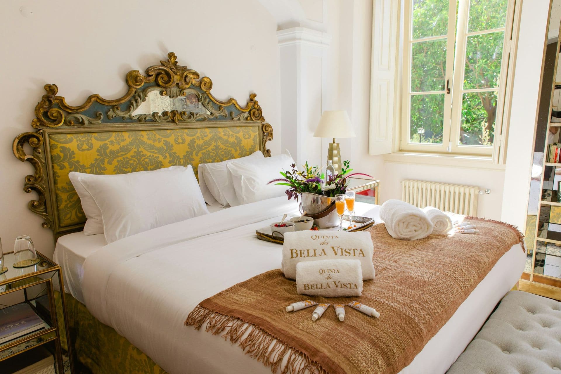 Bedroom with a gilded antique headboard and garden view at Romantic Outlook
