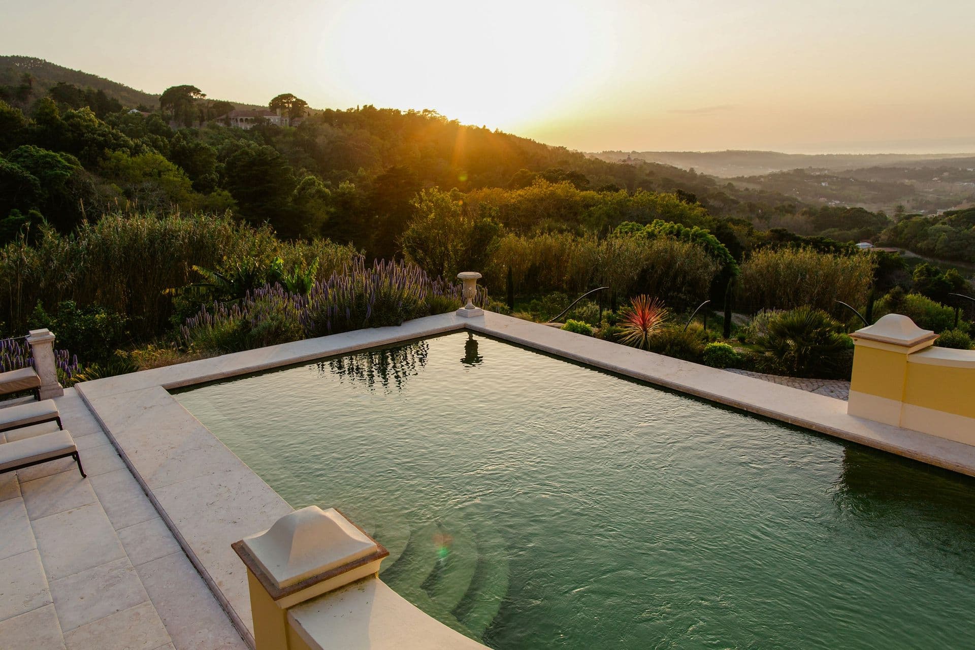Long rectangular pool at dusk framed by the gardens at Romantic Outlook