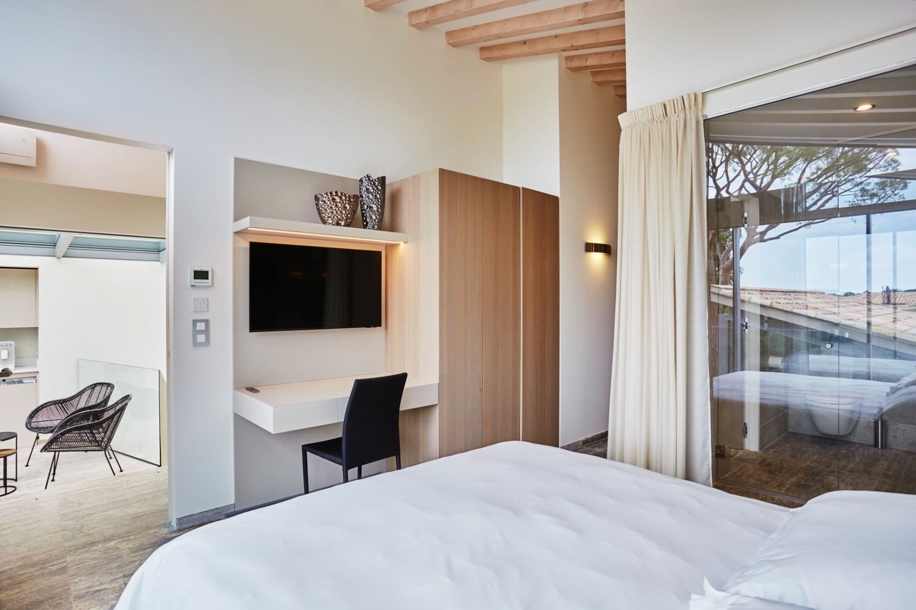 Bedroom with a workspace desk, television and seating area