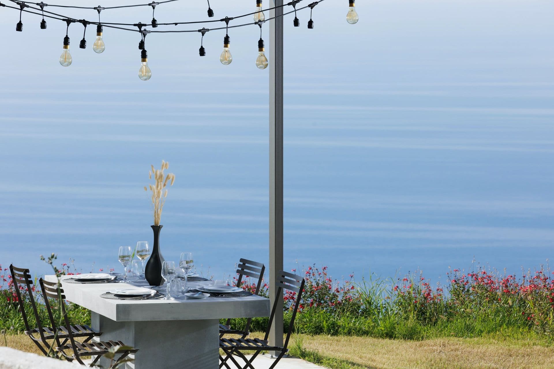 Outdoor dining table with festoon lights above the Ionian Sea at Corfu Dreams, Corfu