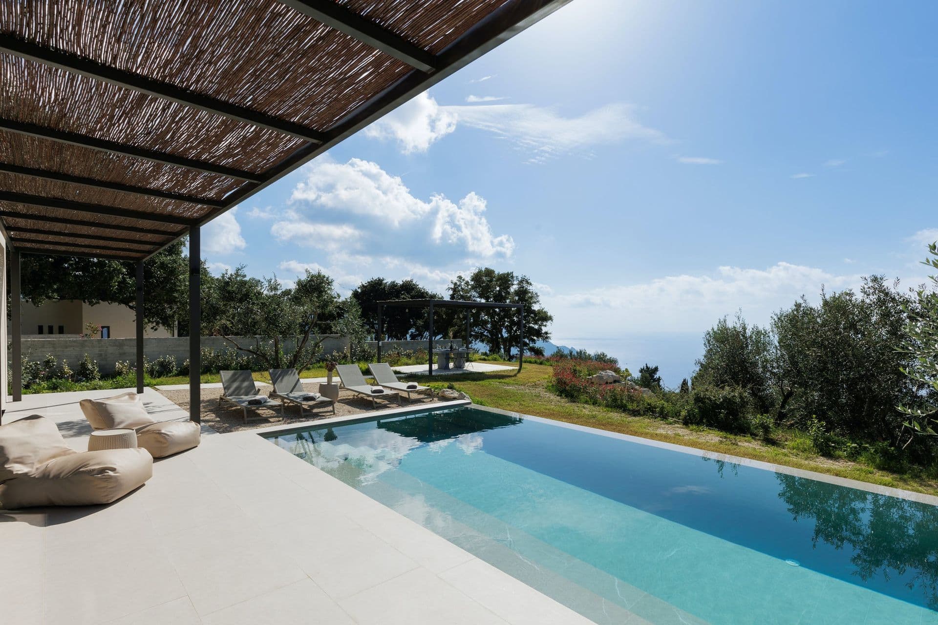 Shaded pergola lounge beside the infinity pool with a sea view at Corfu Dreams, Corfu