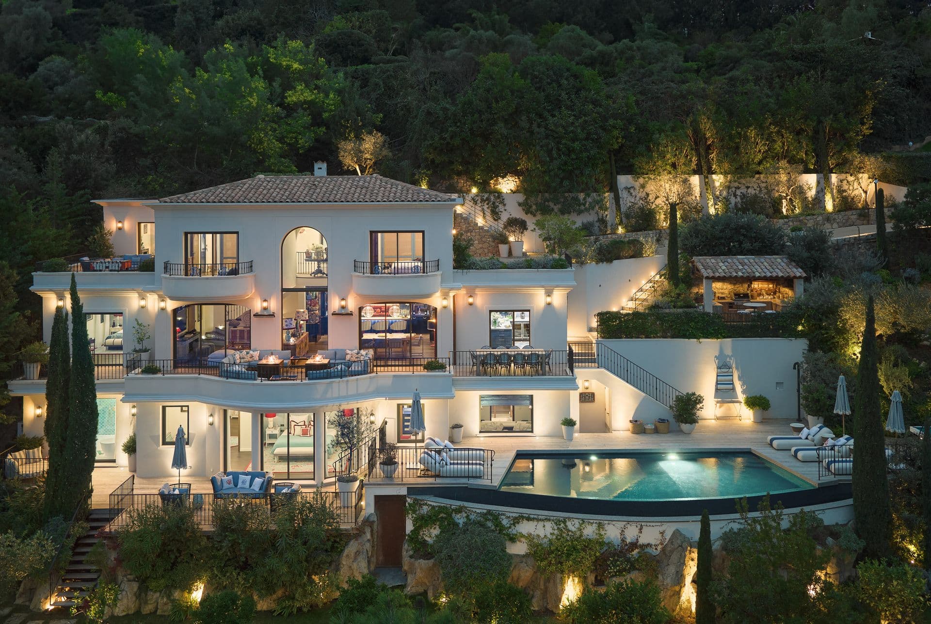 Aerial twilight view of The Riviera Charm villa illuminated above its infinity pool on the French Riviera