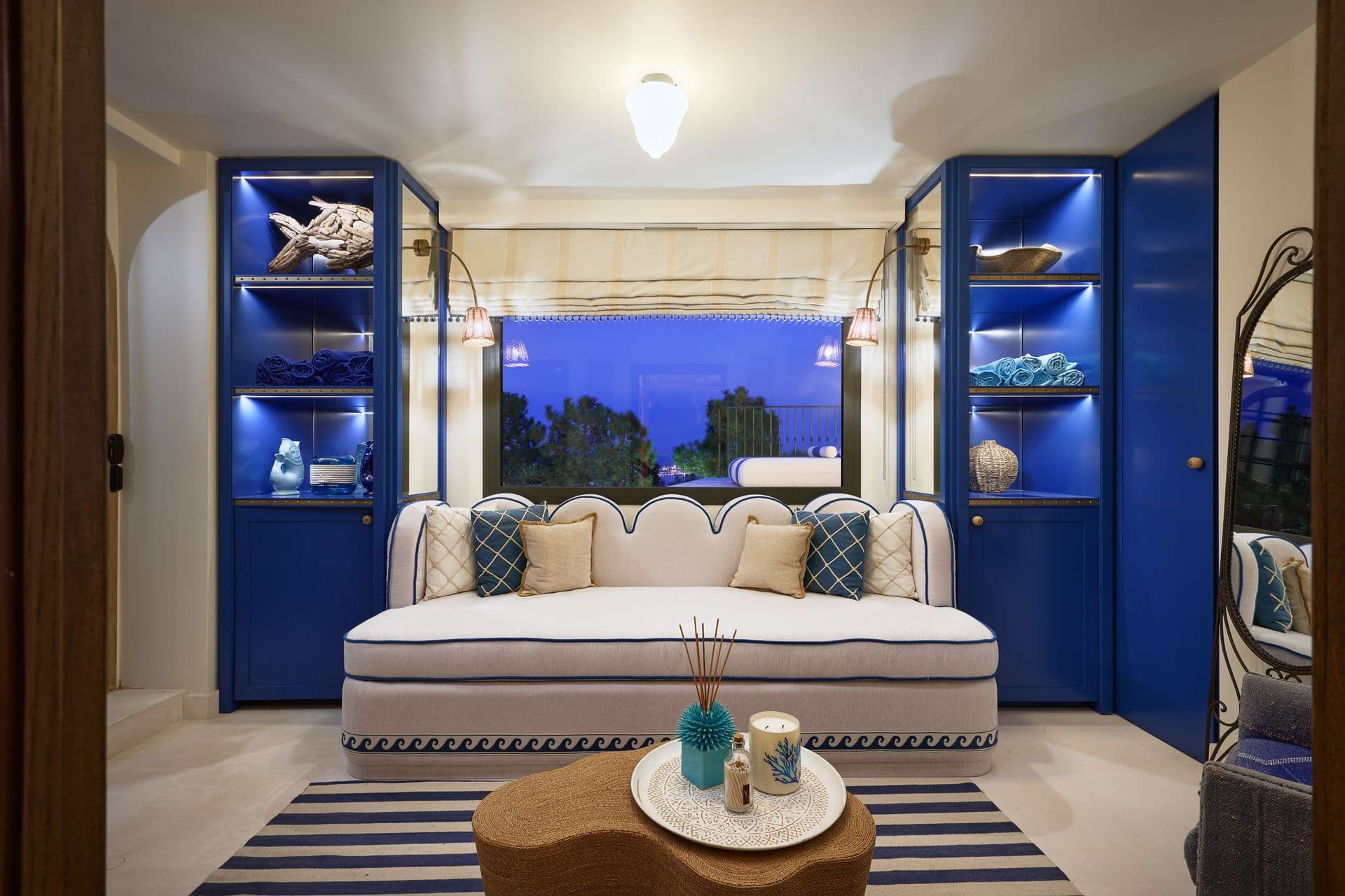 A cosy lounge with navy built-in shelving and a cream sofa