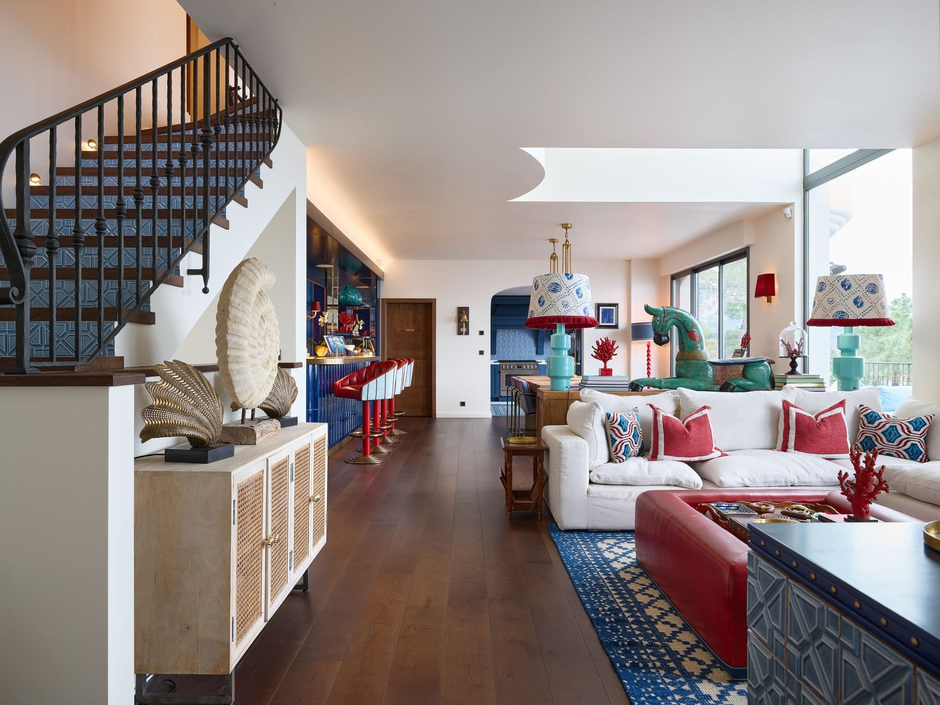 A vividly styled open hallway leading into the living areas with a spiral staircase