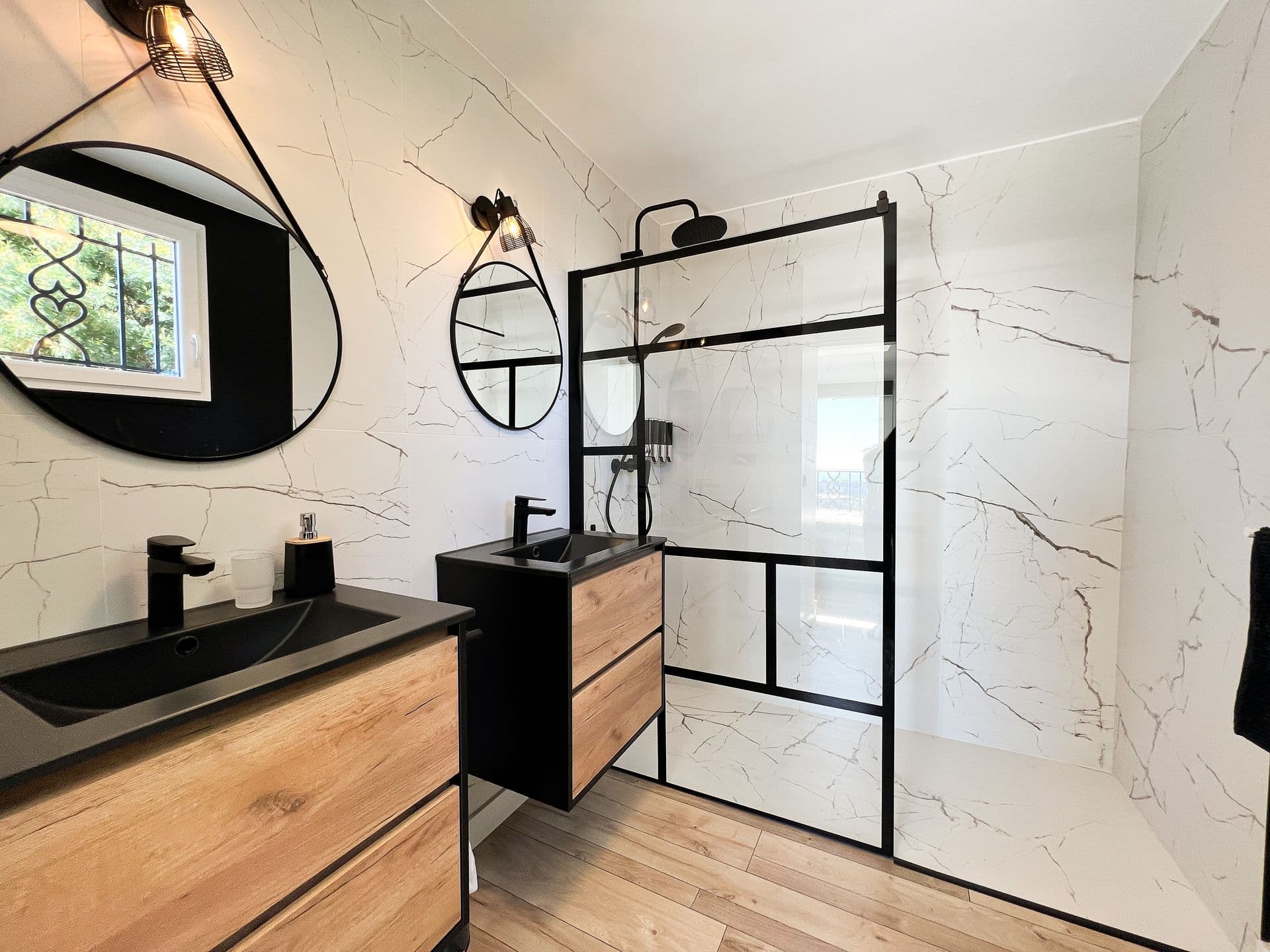 Bathroom with marble walls and a black-framed walk-in shower at Southern Beauty