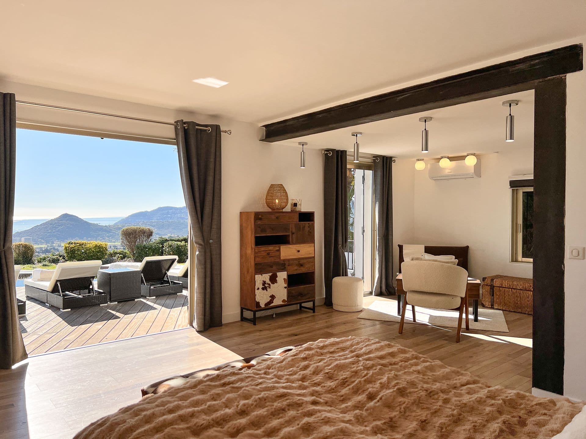 Bedroom in warm brown tones opening onto a terrace with mountain views at Southern Beauty