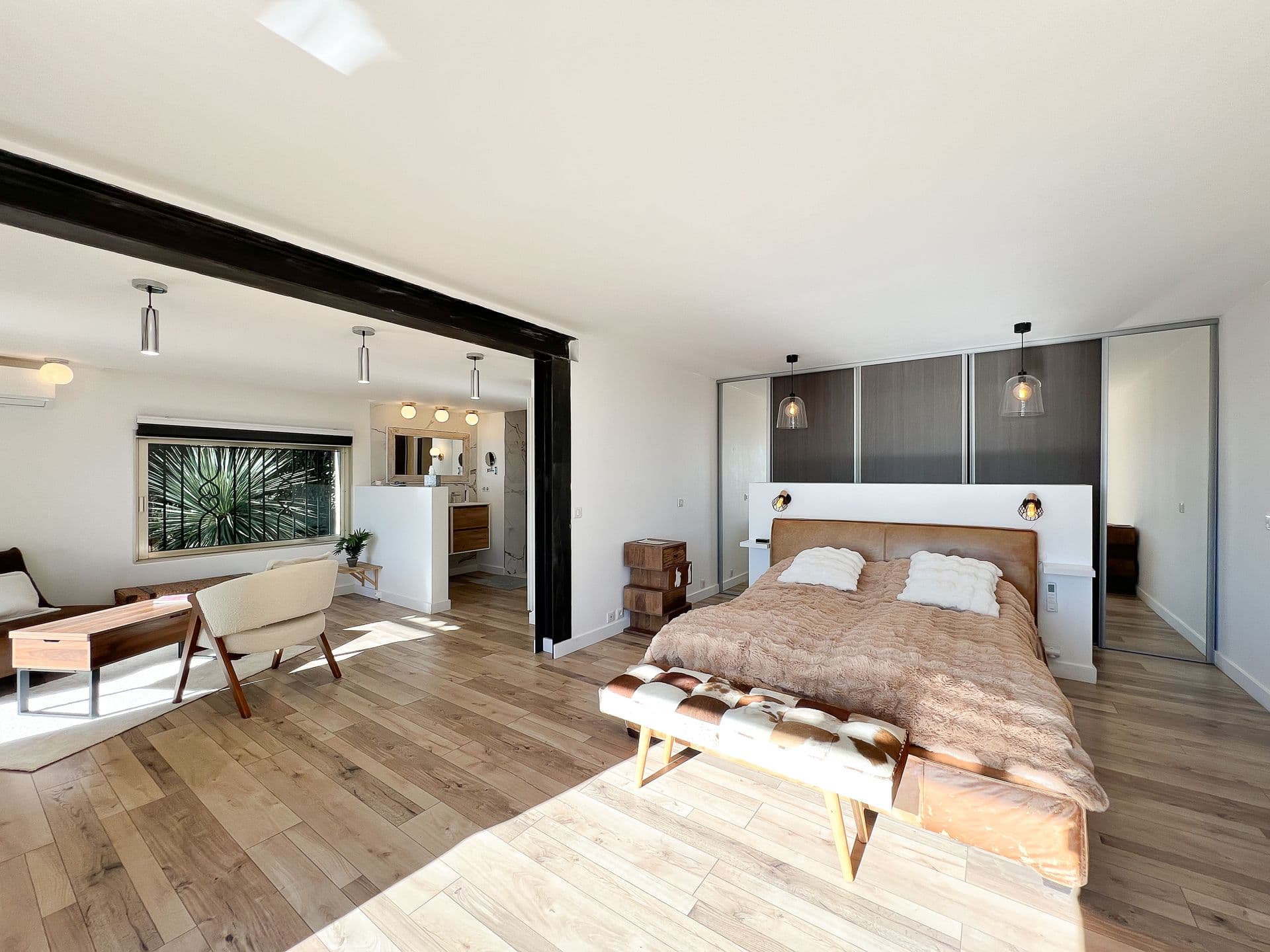 Bedroom with wood flooring and an upholstered bench at Southern Beauty