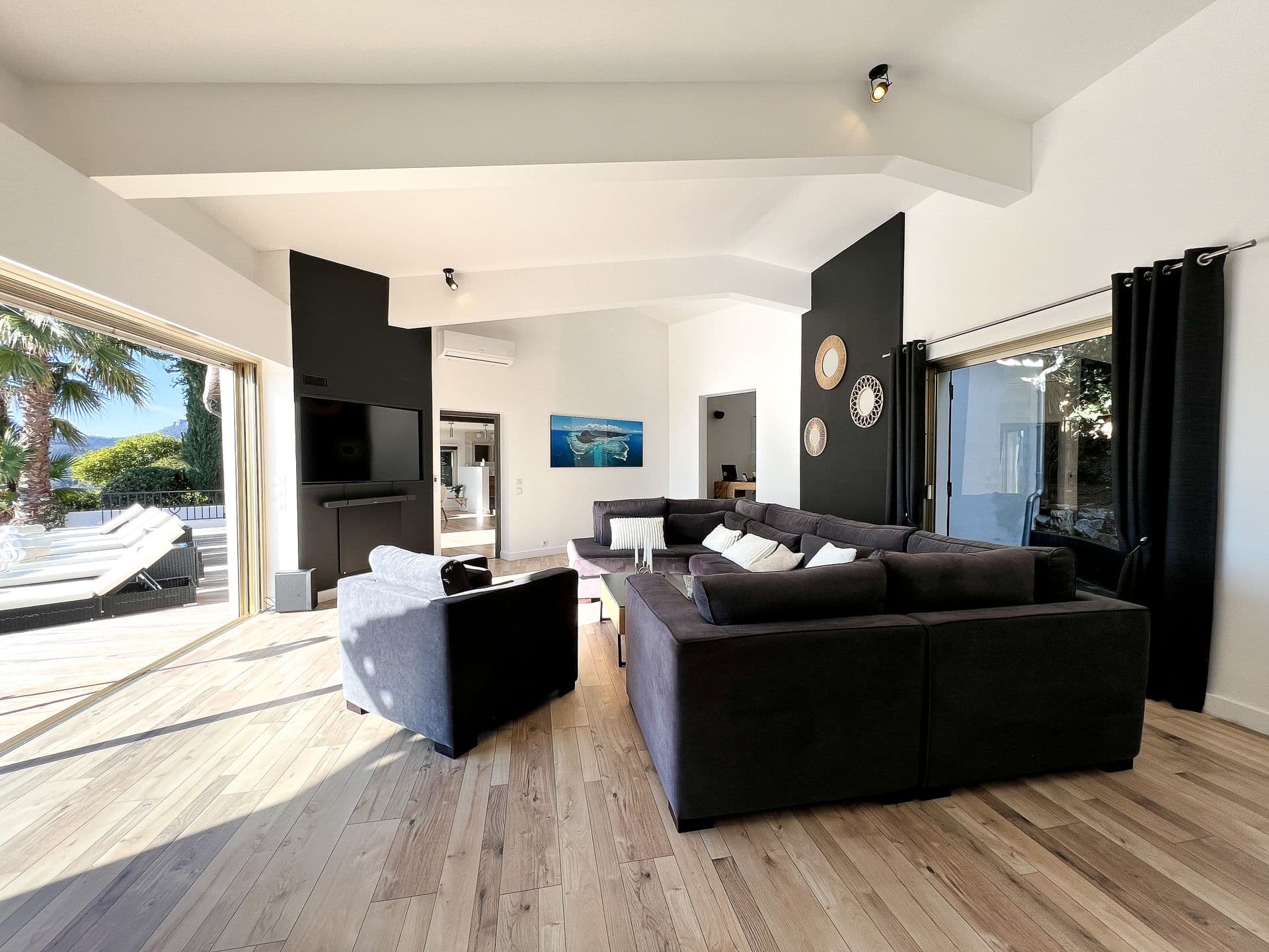 Living room with black leather sofas and wood flooring at Southern Beauty