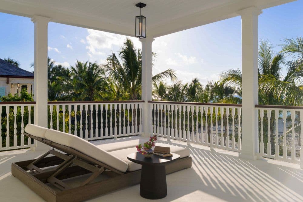 Private balcony with a double daybed and palm views at Sea Breeze Estate