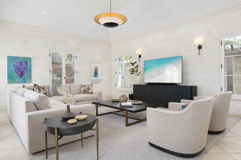Media room with a large screen and deep sofas within coral-stone walls at Sea Breeze Estate