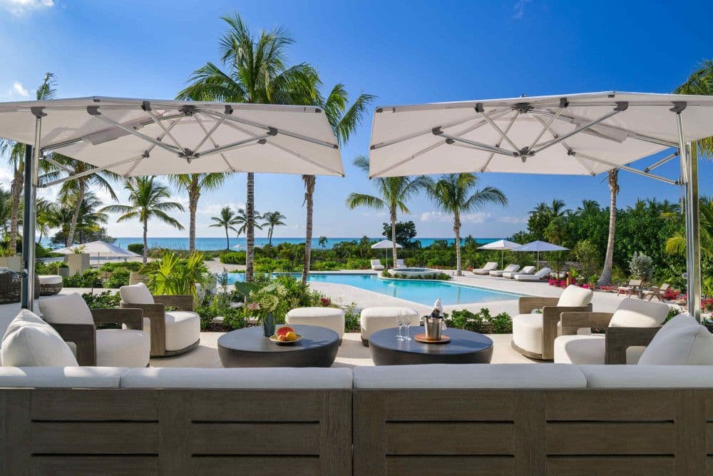 Shaded poolside lounge with parasols and sea views at Sea Breeze Estate